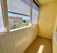 Ein verglaster Balkon mit Blick auf Wohnblöcke, Teil einer Einzimmerwohnung.