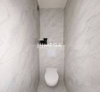 Toilette mit minimalistischem Design und hellen Keramikfliesen in einer 3-Zimmer-Wohnung.