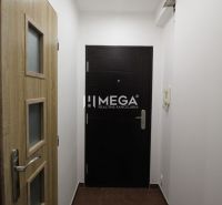 Eingang zum Ferienapartment mit hellen Wänden und Türen in Holzoptik.