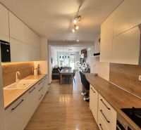 Küche in einer 3-Zimmer-Wohnung mit Holzboden und weißen Schränken.