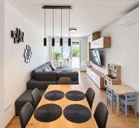Ein geräumiges Wohnzimmer in einer 3-Zimmer-Wohnung mit Holzboden und einem bequemen Sofa.