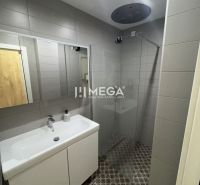 Badezimmer in einer 3-Zimmer-Wohnung mit Duschkabine, Waschbecken und gemustertem Boden.