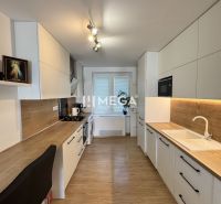 Küche in einer 3-Zimmer-Wohnung mit Holzboden und weißen Schränken.