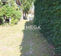Der Garten beim Einfamilienhaus in der Kudlovská-Straße in Humenné, gesäumt von Kletterpflanzen und einem Zaun.