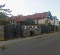 Ein Einfamilienhaus in der Kudlovská-Straße in Humenné mit einer Steinmauer und einem roten Dach.