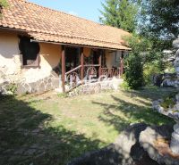 Ein Einfamilienhaus in der Kudlovska-Straße in Humenné mit einer Steinfassade und einem Gartenbrunnen.