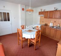Eine Küche in einem Einfamilienhaus mit Holzdekor-Schränken und einem runden Tisch.