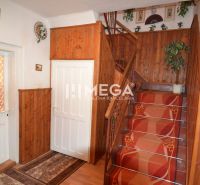 Eine Treppe in einem Einfamilienhaus mit Holzverkleidungen und rotem Teppich.