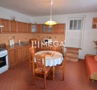 Küche in einem Einfamilienhaus mit Holzschränken und Esstisch.