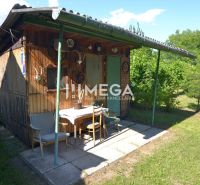 Kleines Holzgartenhaus mit Überdachung im Garten eines Einfamilienhauses in Hažín nad Cirochou.