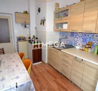 Küche in einem Einfamilienhaus mit Holzboden und farbiger Fliesenverkleidung.