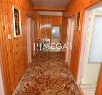 Ein Flur in einem Einfamilienhaus mit Holzverkleidung und einem Teppich mit Ornamenten.