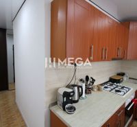 Küche mit braunen Schränken und Geräten in einer 3-Zimmer-Wohnung, Boden mit Holzdekor.