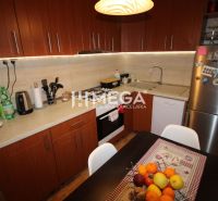 Küche in einer 3-Zimmer-Wohnung, mit Holzschränken und Obst auf dem Tisch.