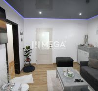 Wohnzimmer mit Sofa, Fernseher und Holzboden in einer 3-Zimmer-Wohnung.