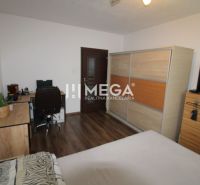 Schlafzimmer mit Schreibtisch, Schrank und Holzboden in einer 3-Zimmer-Wohnung.