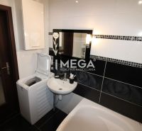 Badezimmer mit Waschbecken, Waschmaschine und Badewanne in einer 3-Zimmer-Wohnung.