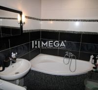 Badezimmer in einer 3-Zimmer-Wohnung mit Dusche, Waschbecken und modernen Fliesen.