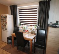Esszimmer in einer 3-Zimmer-Wohnung mit Esstisch, schwarzen Stühlen und Kühlschrank.