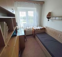 Ein Zimmer in einem Einfamilienhaus mit einem Bett, einem Tisch und Bücherregalen.