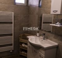 Badezimmer mit Waschbecken, Schrank, Handtuchheizkörper und Boden mit Holzdekor.