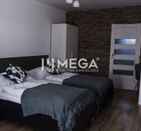 Ein Zimmerinterieur mit zwei Betten, eine Wand mit Steindekor, ein Boden mit Holzdekor.