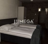 Ein Zimmer mit zwei Betten, einem Tisch und einem Boden mit Holzdekor. Hotels und Pensionen.
