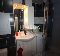 Badezimmer in der Ferienwohnung mit Duschkabine, Waschbecken und Waschmaschine.