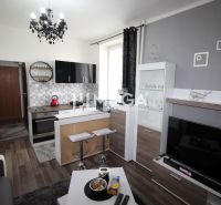 Küche in der Ferienwohnung mit Sofa und Holzboden.