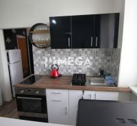 Küche in der Ferienwohnung mit Holzboden und geometrischen Fliesen an der Wand.