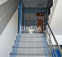 Treppe im Büro mit blauen und grauen Fliesen, Metallgeländer und Holztüren.