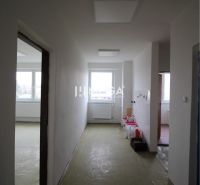 Ein Flur im Büro ohne Bodenbelag mit Holzdekor, bereit zur Renovierung.