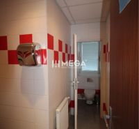 Sanitäreinrichtung in Büros mit weißen und roten Fliesen.