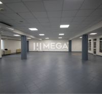 Geräumige Geschäftsräume mit dunklen Fliesen und abgehängter Decke, geeignet für Unternehmen.
