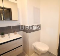 Badezimmer in einer 2-Zimmer-Wohnung mit Waschbecken, Spiegel und Toilette.