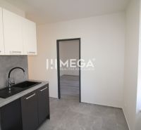 Küche mit schwarzem Spülbecken und weißen Schränken in einer 2-Zimmer-Wohnung.
