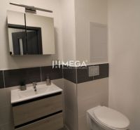 Badezimmer in einer 2-Zimmer-Wohnung mit Fliesen, einem Schrank und einem Spiegel über dem Waschbecken.