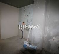 Unvollendetes Interieur in einem Einfamilienhaus mit Betonboden und Anschluss für einen Heizkörper.