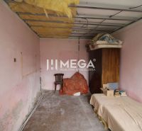 Ein Zimmer in einem Einfamilienhaus mit rosa Wänden, einem Bett und einem Schrank.