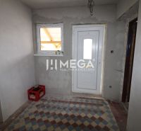 Eingang in einem Einfamilienhaus mit weißen Türen und Fliesen mit geometrischem Muster.