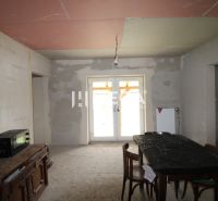 Unvollendetes Interieur mit Küchentisch, Stühlen und Schrank in einem Einfamilienhaus.