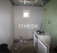 Ein Zimmer in einem Einfamilienhaus mit Fenster, eine unvollendete Wand und ein alter Tresen.