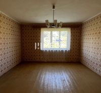 Ein Zimmer mit Tapeten und einem Boden in Holzoptik in einem Einfamilienhaus.