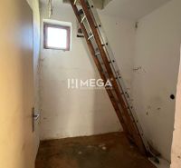 Eine Leiter führt auf den Dachboden in einem Einfamilienhaus mit einem Boden in Holzoptik.