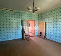Ein Zimmer mit Tapeten in einem Einfamilienhaus mit Holzboden und Kacheln.