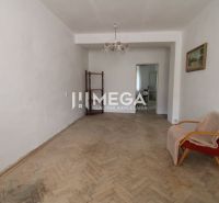 Wohnzimmer mit einem alten Sessel und einem Boden mit Holzdekor in einer 2-Zimmer-Wohnung.