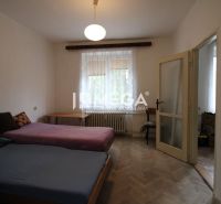 Schlafzimmer mit zwei Betten und Holzboden in einer 2-Zimmer-Wohnung.