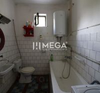 Badezimmer in einem Einfamilienhaus mit Badewanne, Waschbecken und einem an der Wand montierten Kessel.