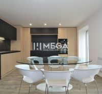 Küche in einer 3-Zimmer-Wohnung mit schwarzer Küchenzeile, rundem Glastisch und Holzboden.