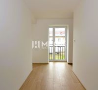 Ein enger Raum mit Holzboden in einer 2-Zimmer-Wohnung, helle Wände.